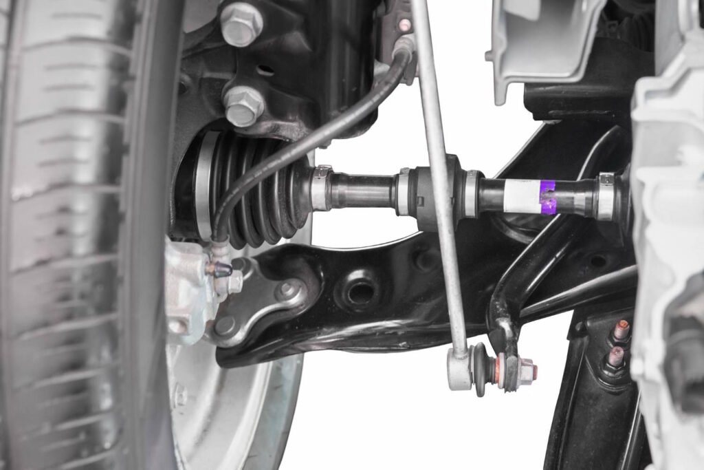 Detailed view of a CV (constant velocity) axle and suspension components in a front-wheel-drive vehicle. The image shows the axle shaft, control arm, and sway bar link, which are crucial for smooth power delivery and stable handling during turns and acceleration.